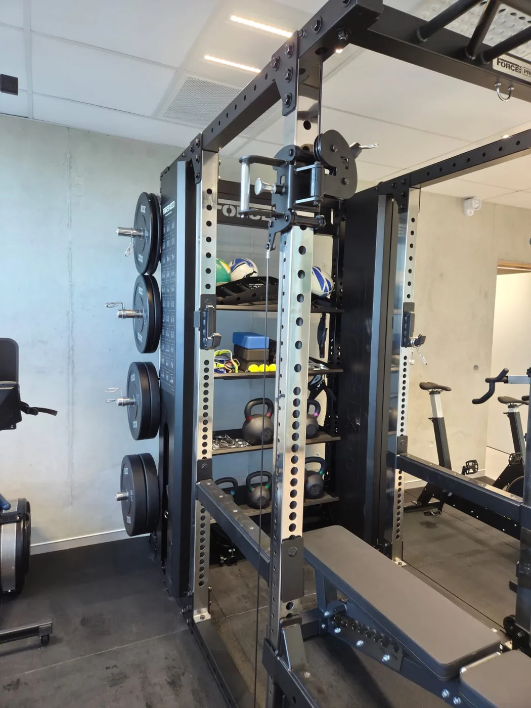 Cage de musculation avec poulie, banc et disques au cabinet Air One Performance